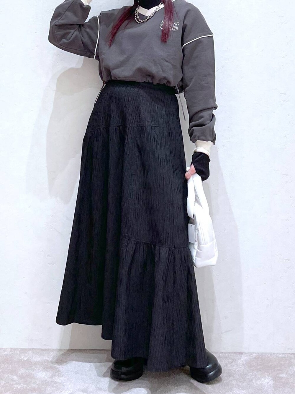 グレー系のスウェット、ブラック系のTシャツ/カットソー、ブラック系のブーツを着用したレディースの冬コーディネートの2枚目の写真