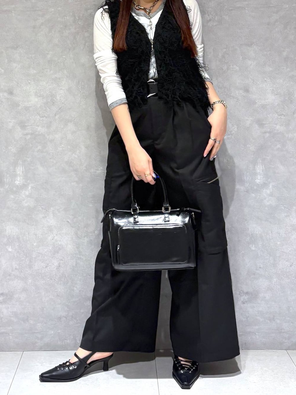 ブラック系のショルダーバッグ、ブラック系のスラックス、ブラック系のサンダルを着用したレディースの春コーディネートの2枚目の写真