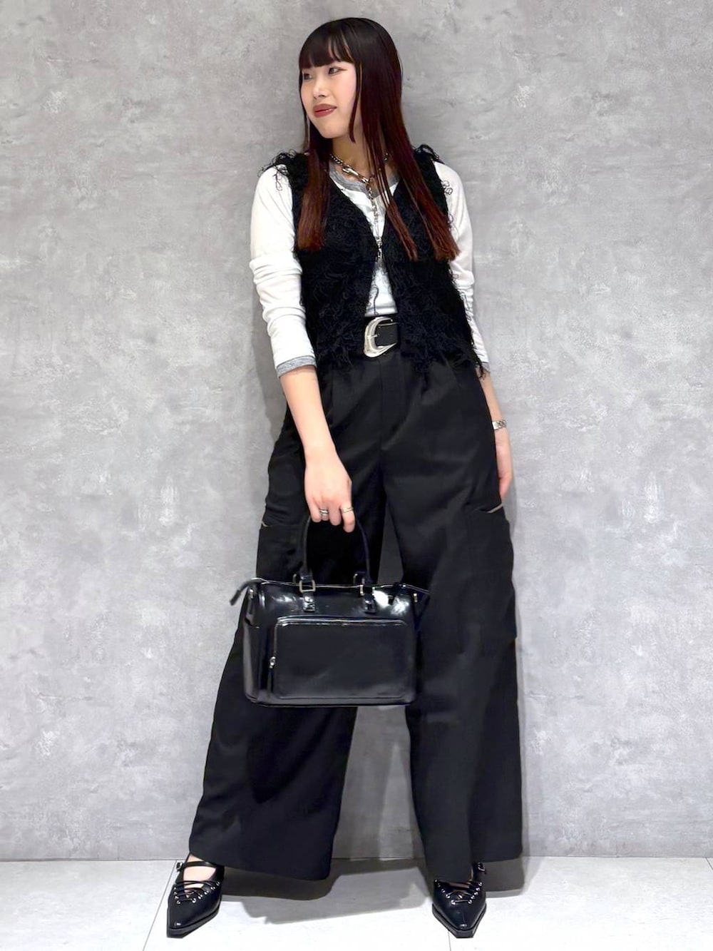 ブラック系のショルダーバッグ、ブラック系のスラックス、ブラック系のサンダルを着用したレディースの春コーディネートの5枚目の写真