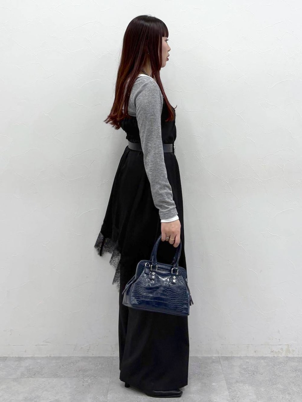 ブルー系のハンドバッグ、ブラック系のスラックス、ブラック系のサンダルを着用したレディースの春コーディネートの7枚目の写真