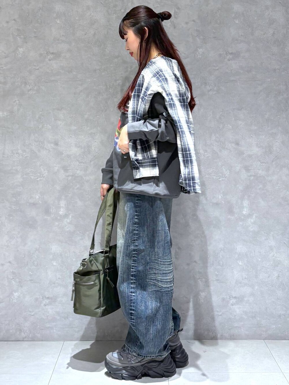 ブラック系のスニーカー、グリーン系のボストンバッグ、ブラック系のスウェットを着用したレディースの秋コーディネートの4枚目の写真