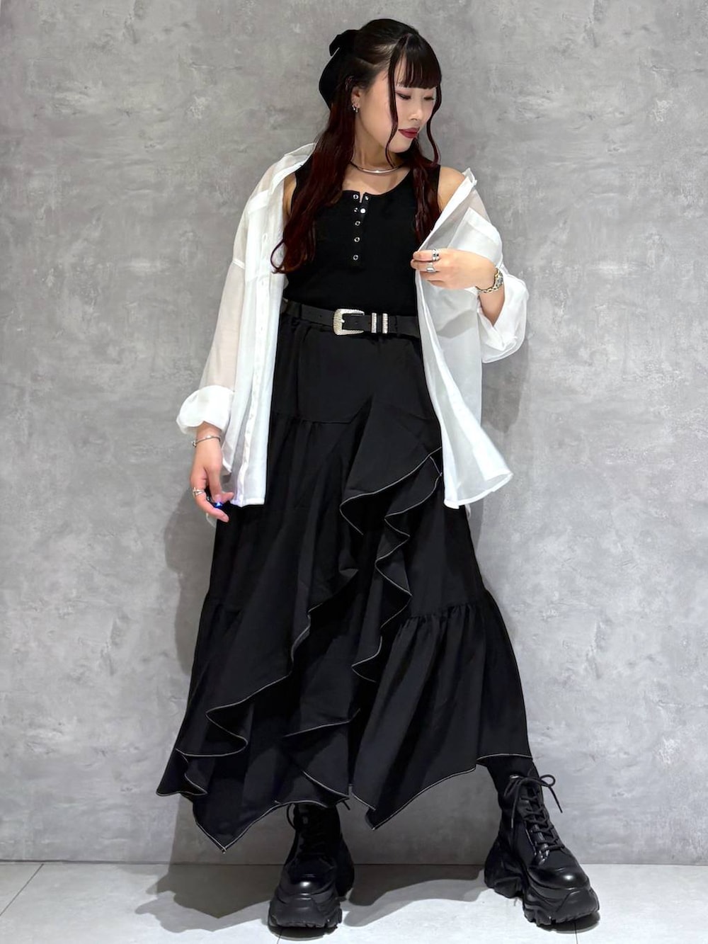 ブラック系のブーツ、ブラック系のスカート、ホワイト系のシャツ/ブラウスを着用したレディースの春コーディネートの8枚目の写真