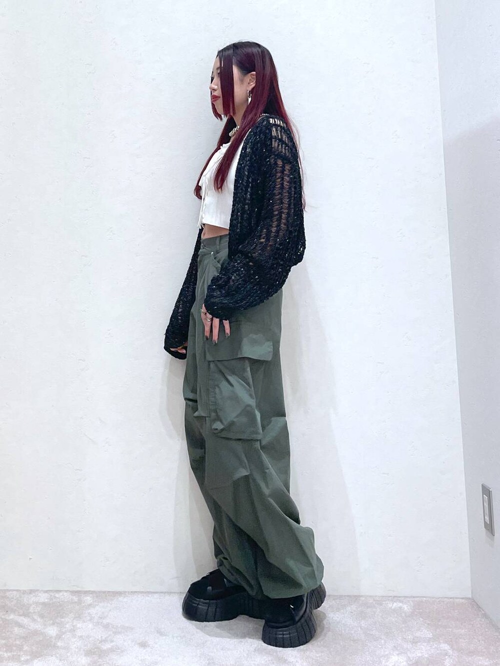 ブラック系のスニーカー、グリーン系のカーゴパンツ、ホワイト系のタンクトップを着用したレディースの春コーディネートの4枚目の写真