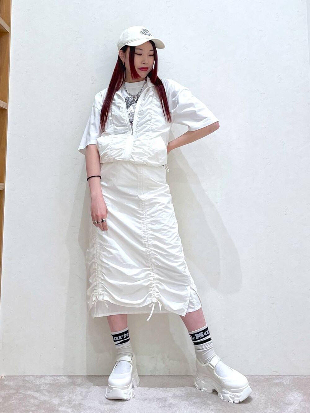 ホワイト系のベスト、ホワイト系のスカート、ホワイト系のTシャツ/カットソーを着用したレディースの春コーディネートの2枚目の写真