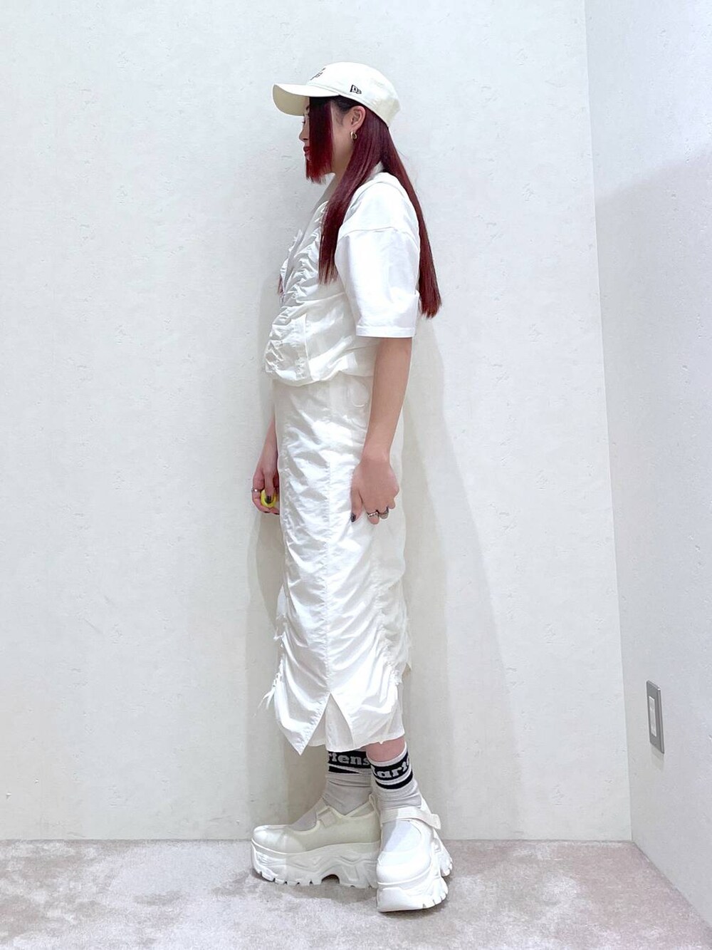 ホワイト系のベスト、ホワイト系のスカート、ホワイト系のTシャツ/カットソーを着用したレディースの春コーディネートの6枚目の写真