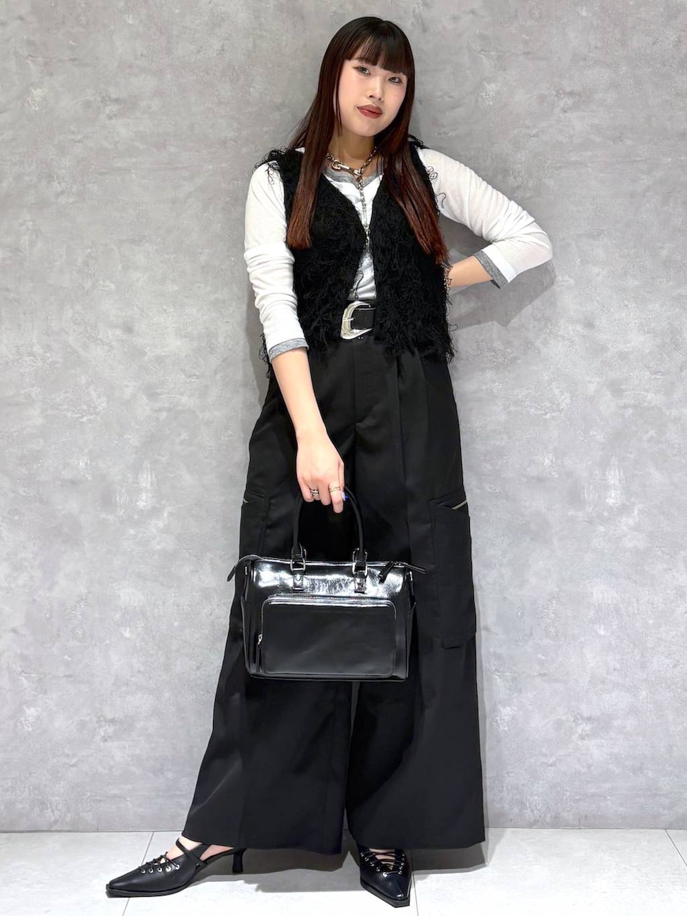 ブラック系のショルダーバッグ、ブラック系のスラックス、ブラック系のサンダルを着用したレディースの春コーディネートの6枚目の写真