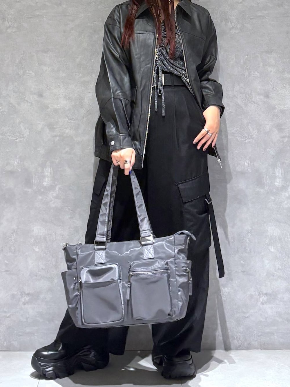 ブラック系のブーツ、グレー系のボストンバッグ、ブラック系のブルゾンを着用したレディースの秋コーディネートの2枚目の写真