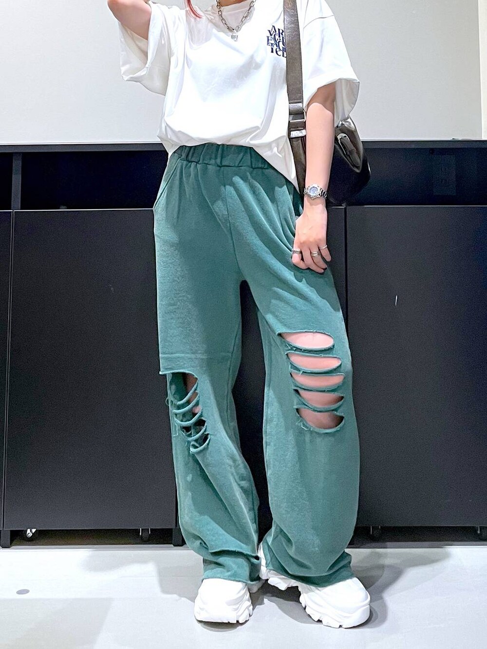 ホワイト系のスニーカー、ホワイト系のTシャツ/カットソー、グリーン系のその他パンツを着用したレディースの秋コーディネートの4枚目の写真