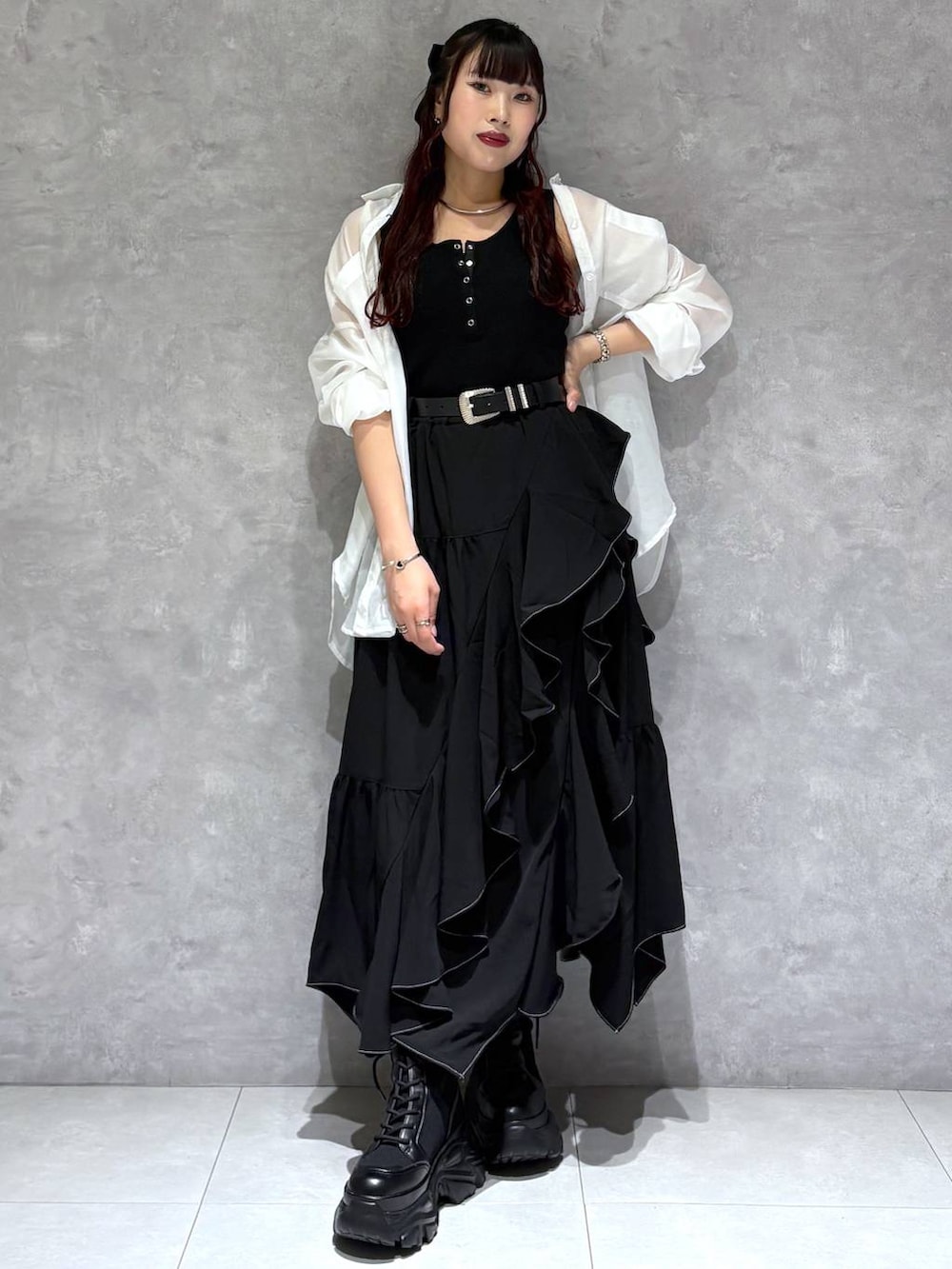 ブラック系のブーツ、ブラック系のスカート、ホワイト系のシャツ/ブラウスを着用したレディースの春コーディネートの2枚目の写真