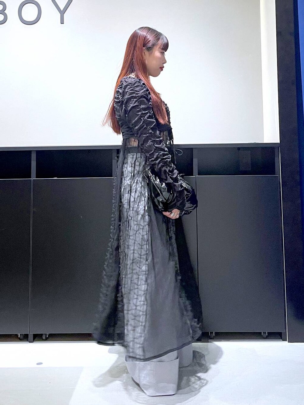 ブラック系のパンプス、ブラック系のショルダーバッグ、ブラック系のワンピースを着用したレディースの夏コーディネートの7枚目の写真