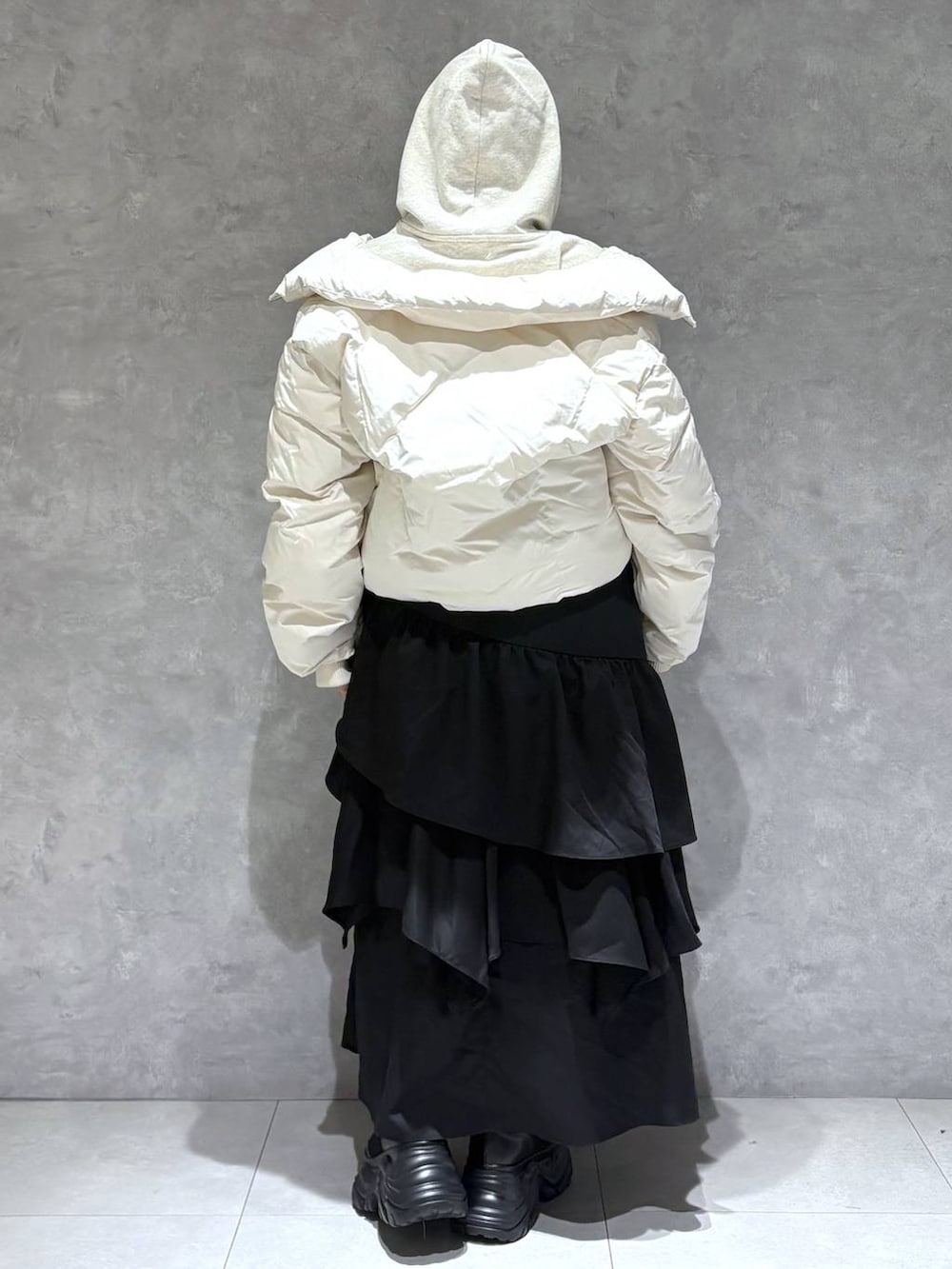 ブラック系のブーツ、ホワイト系のブルゾン、ベージュ系のパーカーを着用したレディースの冬コーディネートの5枚目の写真