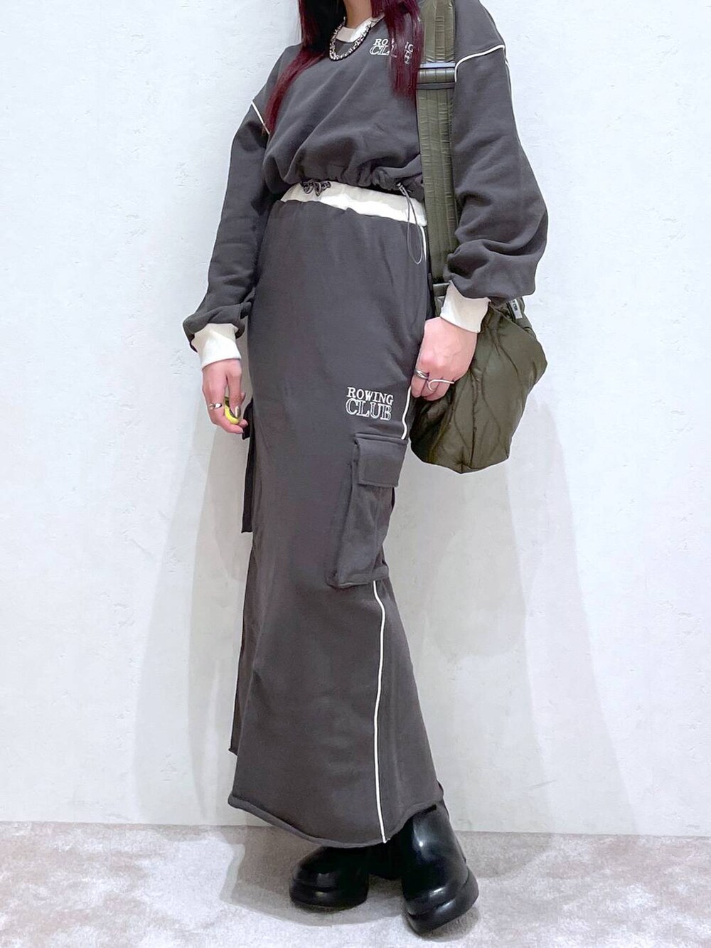 グレー系のスウェット、グレー系のスカート、ブラック系のブーツを着用したレディースの冬コーディネートの3枚目の写真