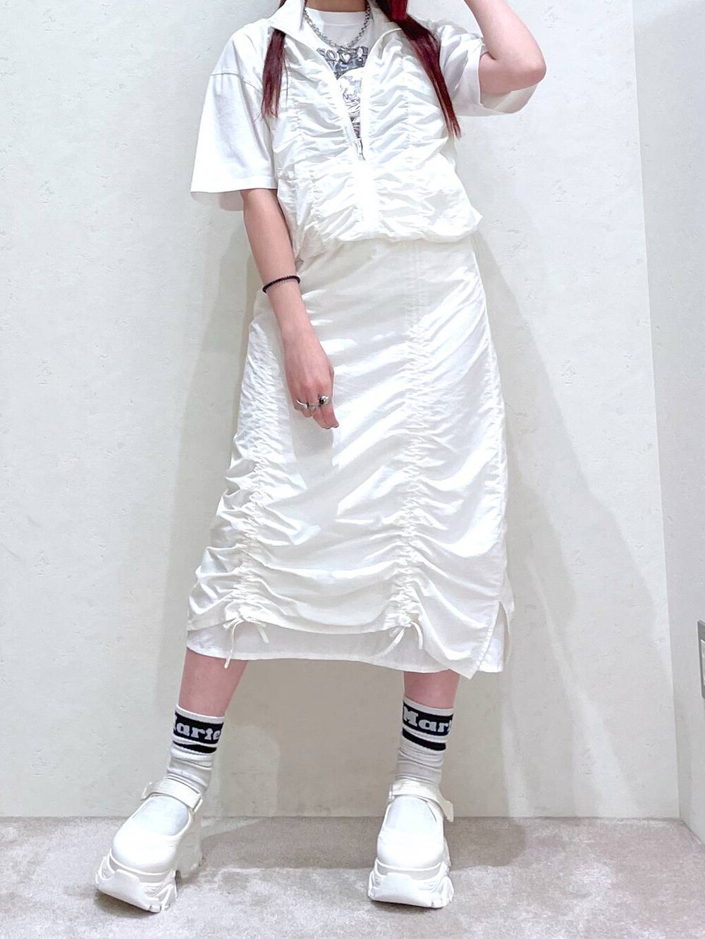 ホワイト系のベスト、ホワイト系のスカート、ホワイト系のTシャツ/カットソーを着用したレディースの春コーディネートの5枚目の写真