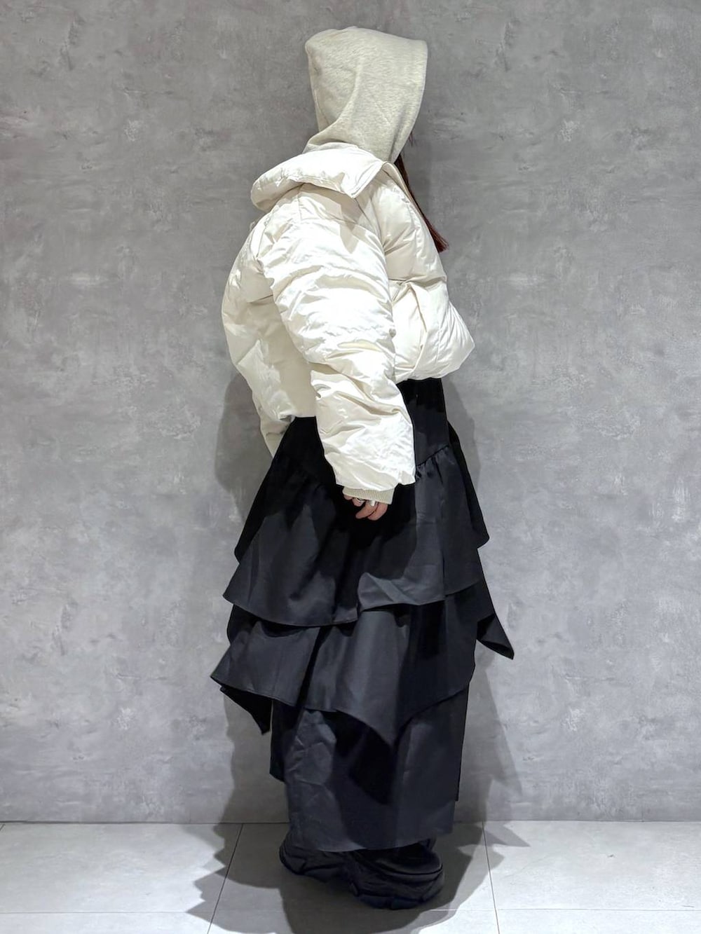 ブラック系のブーツ、ホワイト系のブルゾン、ベージュ系のパーカーを着用したレディースの冬コーディネートの6枚目の写真