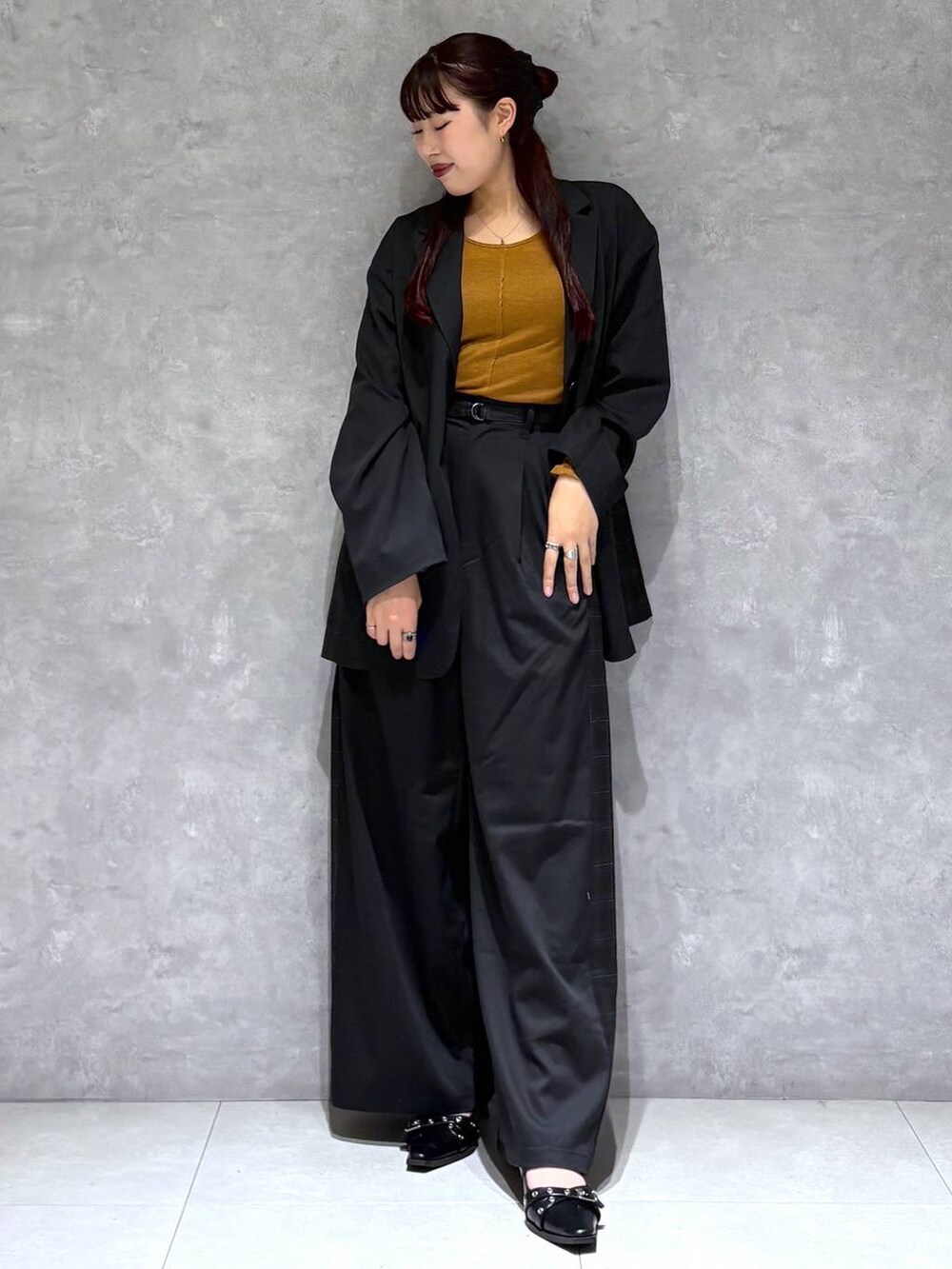 ブラック系のパンプス、ブラック系のテーラードジャケット、グレー系のスラックスを着用したレディースの秋コーディネートの3枚目の写真