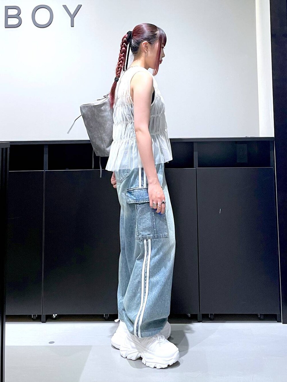 ホワイト系のスニーカー、ブルー系のデニムパンツ、グレー系のショルダーバッグを着用したレディースの夏コーディネートの7枚目の写真