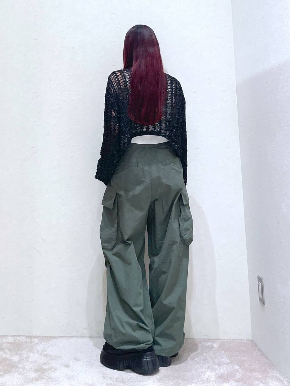 ブラック系のスニーカー、グリーン系のカーゴパンツ、ホワイト系のタンクトップを着用したレディースの春コーディネートの5枚目の写真