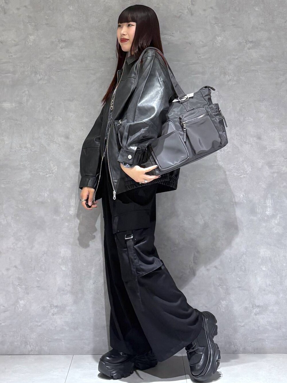 ブラック系のブーツ、グレー系のボストンバッグ、ブラック系のブルゾンを着用したレディースの秋コーディネートの9枚目の写真