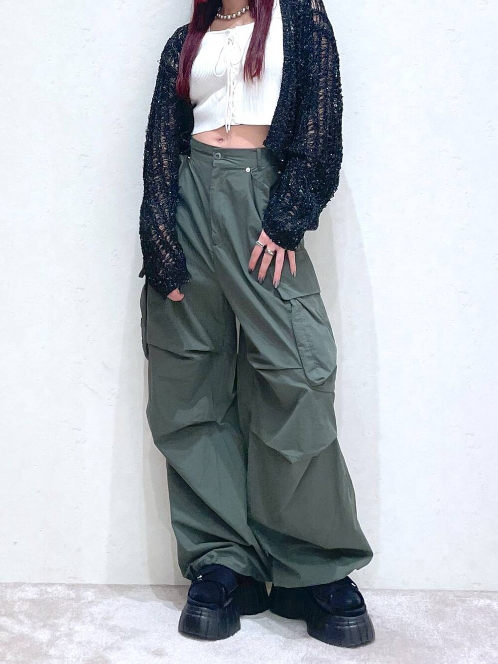 ブラック系のスニーカー、グリーン系のカーゴパンツ、ホワイト系のタンクトップを着用したレディースの春コーディネートの3枚目の写真