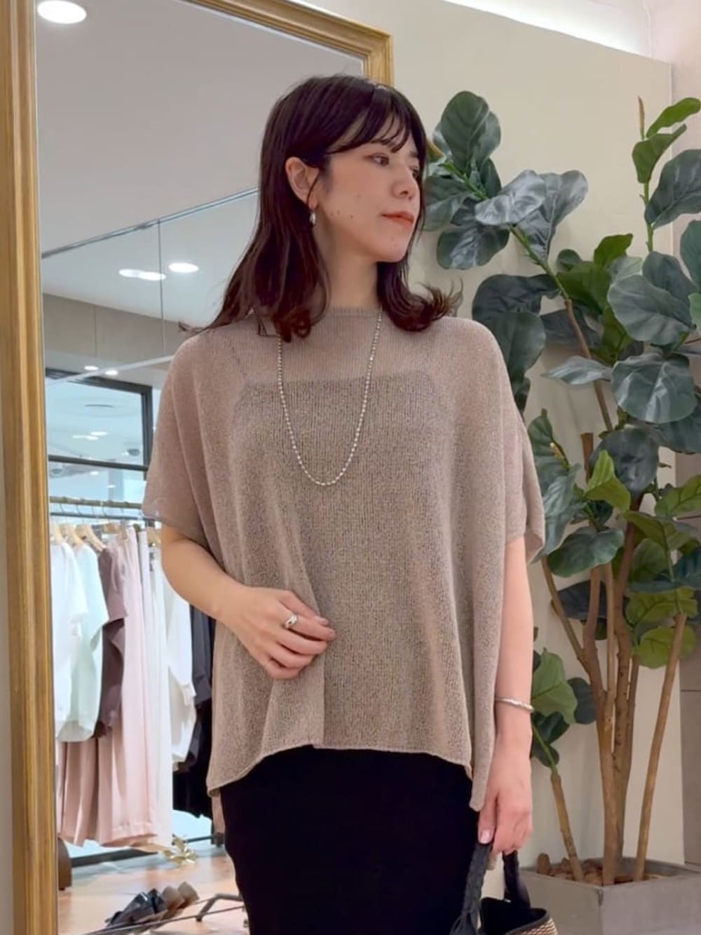 ブラウン系のニット/セーター、ブラック系のキャミソール、ブラック系のスカートを着用したレディースの夏コーディネートの2枚目の写真