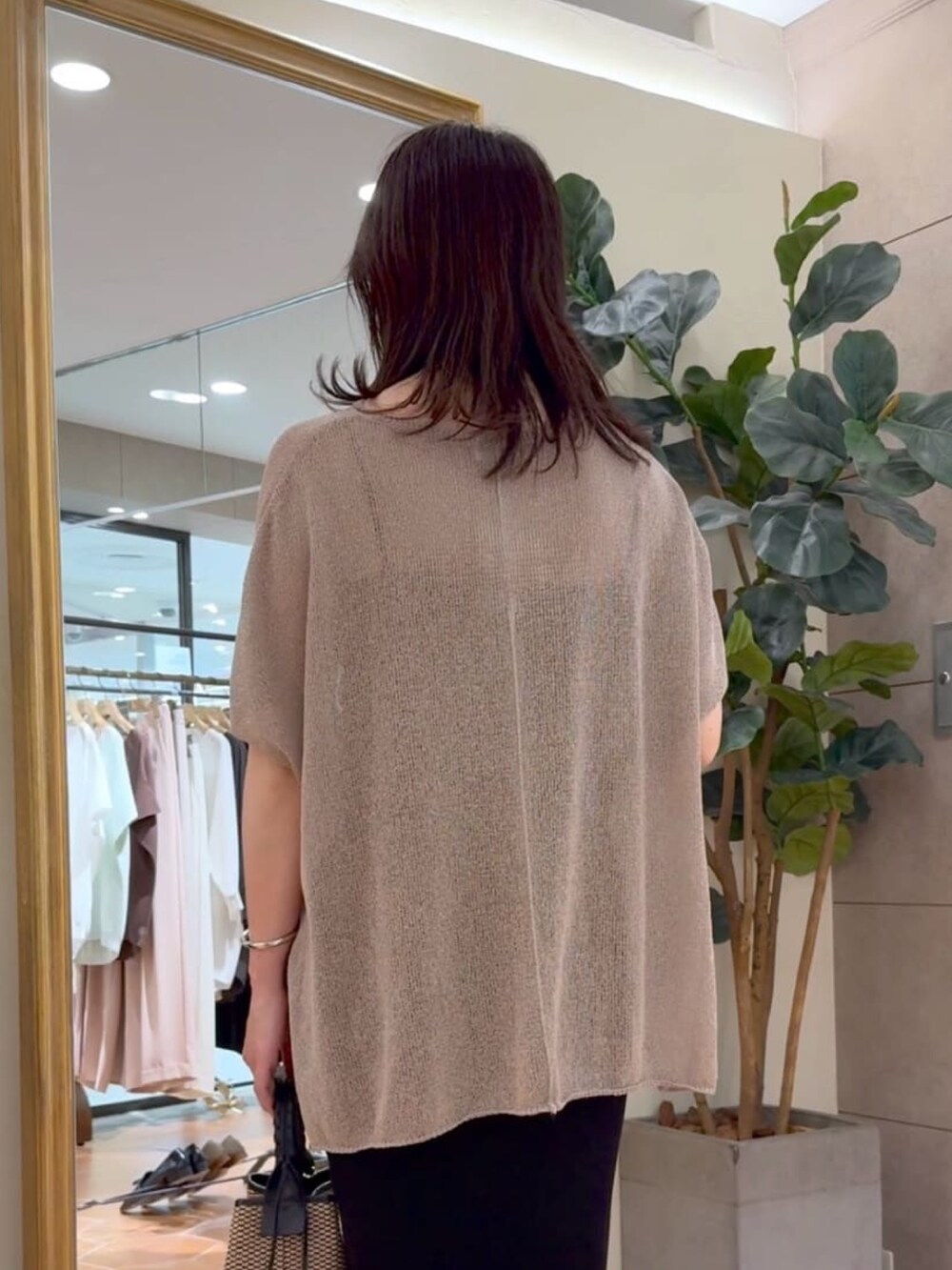 ブラウン系のニット/セーター、ブラック系のキャミソール、ブラック系のスカートを着用したレディースの夏コーディネートの4枚目の写真