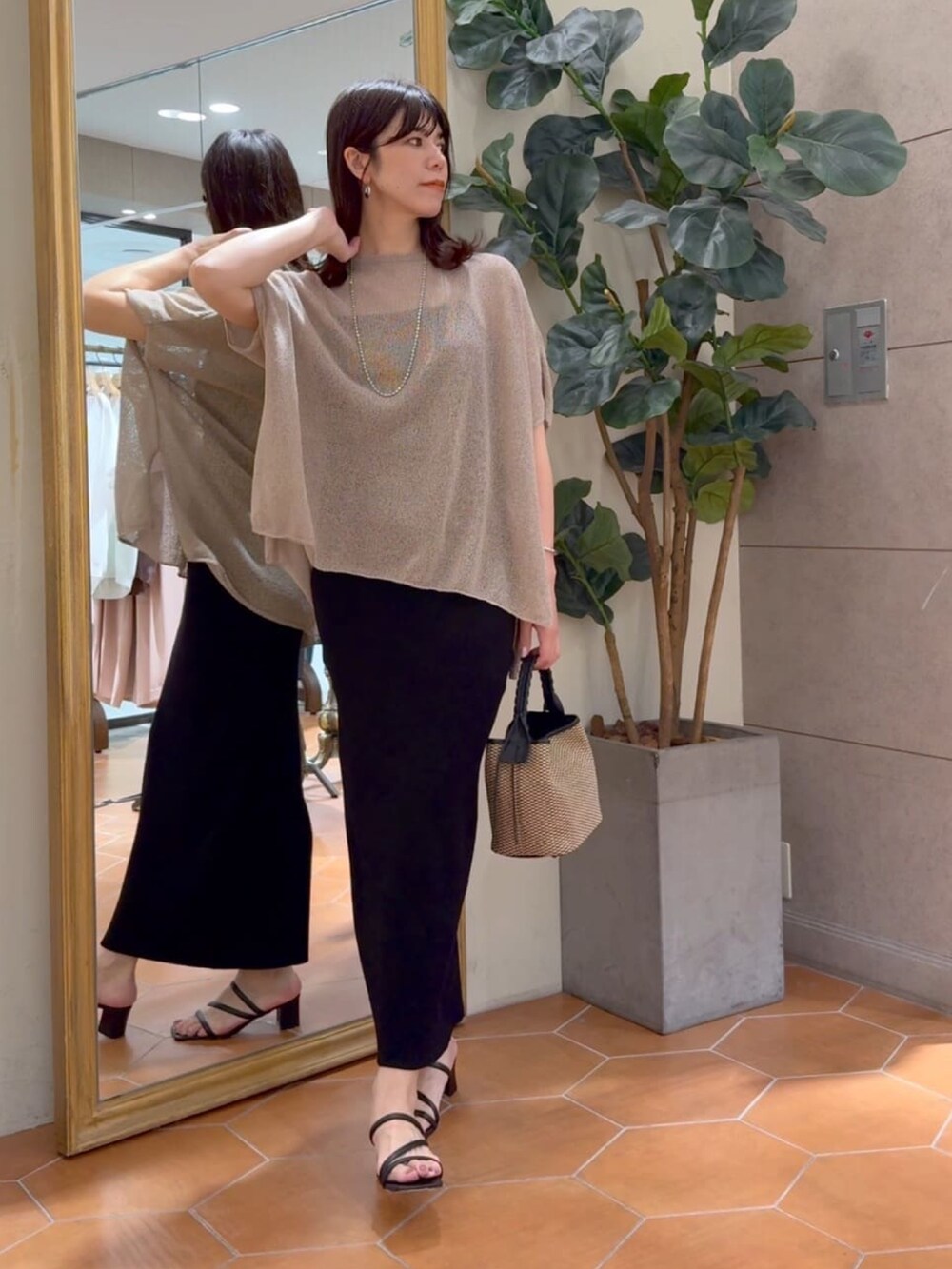 ブラウン系のニット/セーター、ブラック系のキャミソール、ブラック系のスカートを着用したレディースの夏コーディネートの5枚目の写真