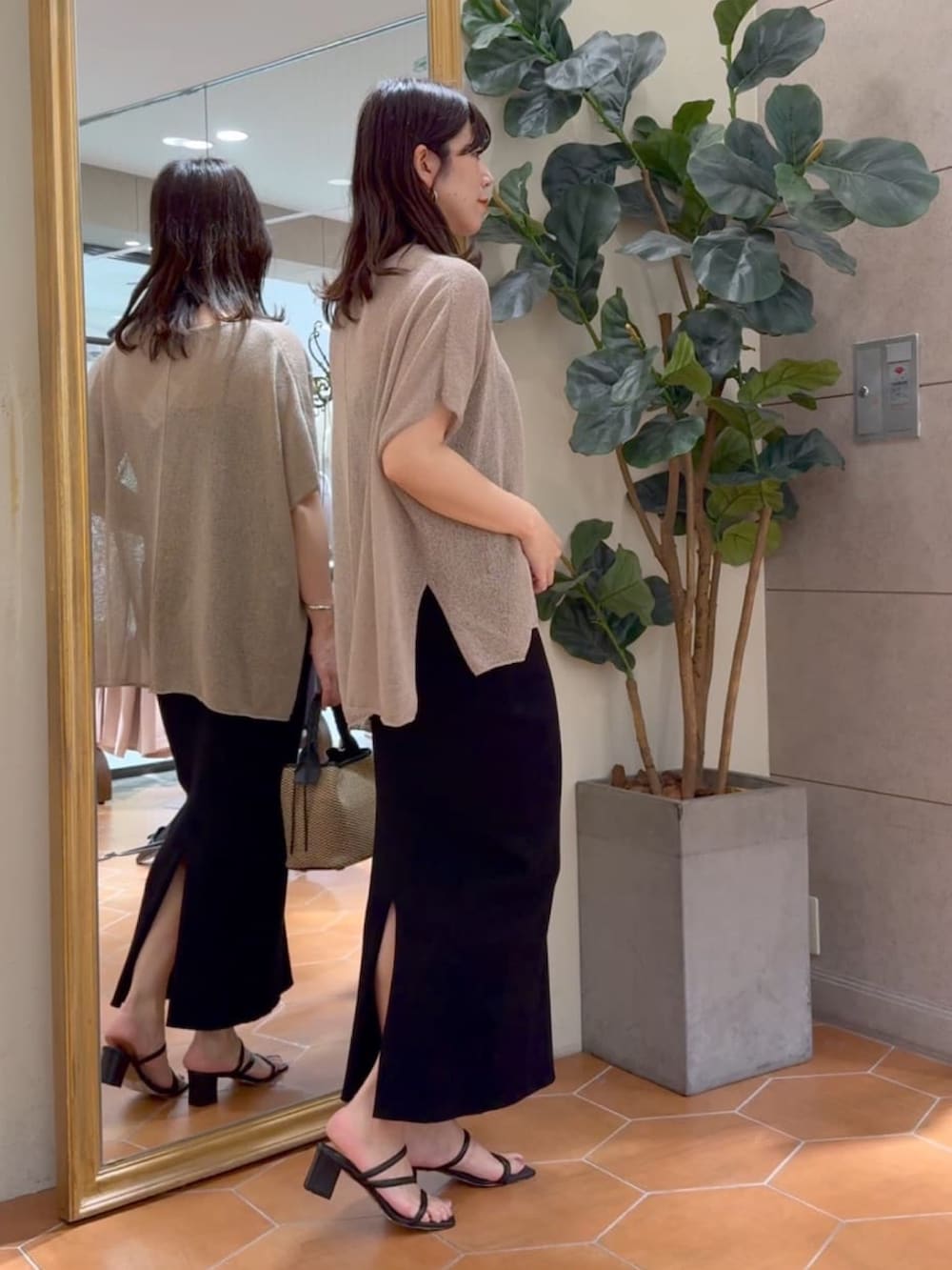 ブラウン系のニット/セーター、ブラック系のキャミソール、ブラック系のスカートを着用したレディースの夏コーディネートの6枚目の写真