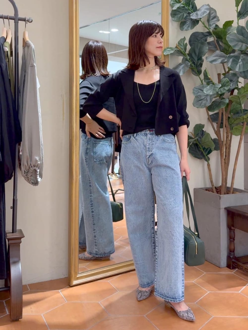 ブラック系のキャミソール、ブラック系のテーラードジャケット、ブルー系のデニムパンツを着用したレディースの夏コーディネートの4枚目の写真