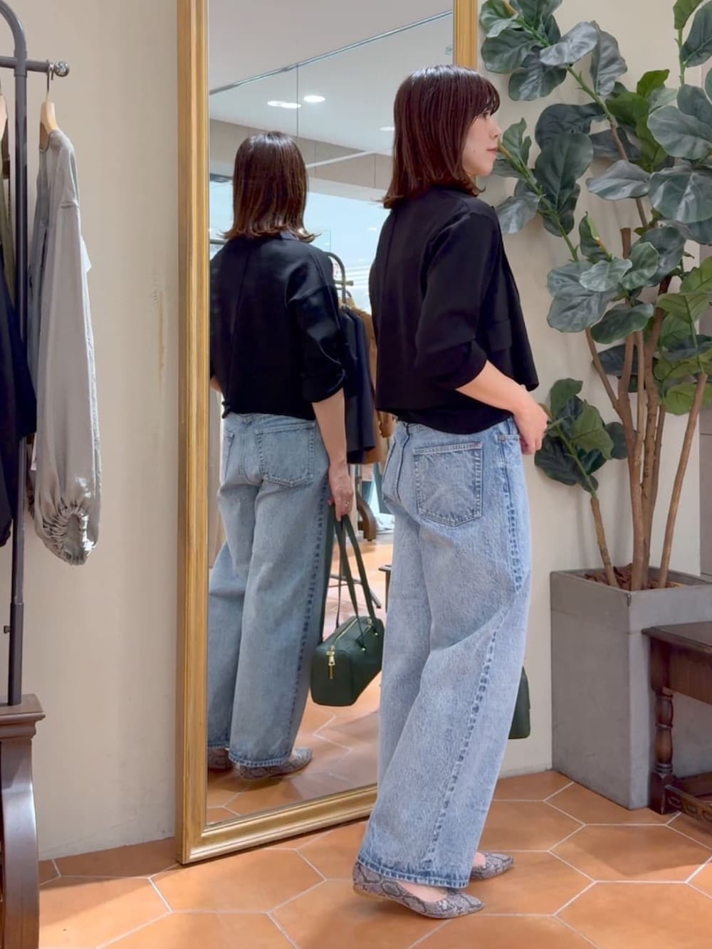 ブラック系のキャミソール、ブラック系のテーラードジャケット、ブルー系のデニムパンツを着用したレディースの夏コーディネートの5枚目の写真