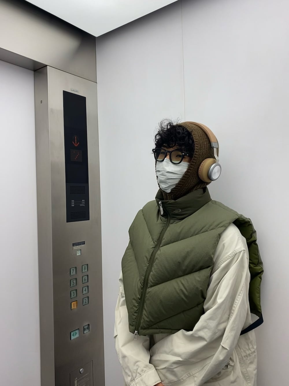 グリーン系のベストを着用したメンズの冬コーディネートの2枚目の写真