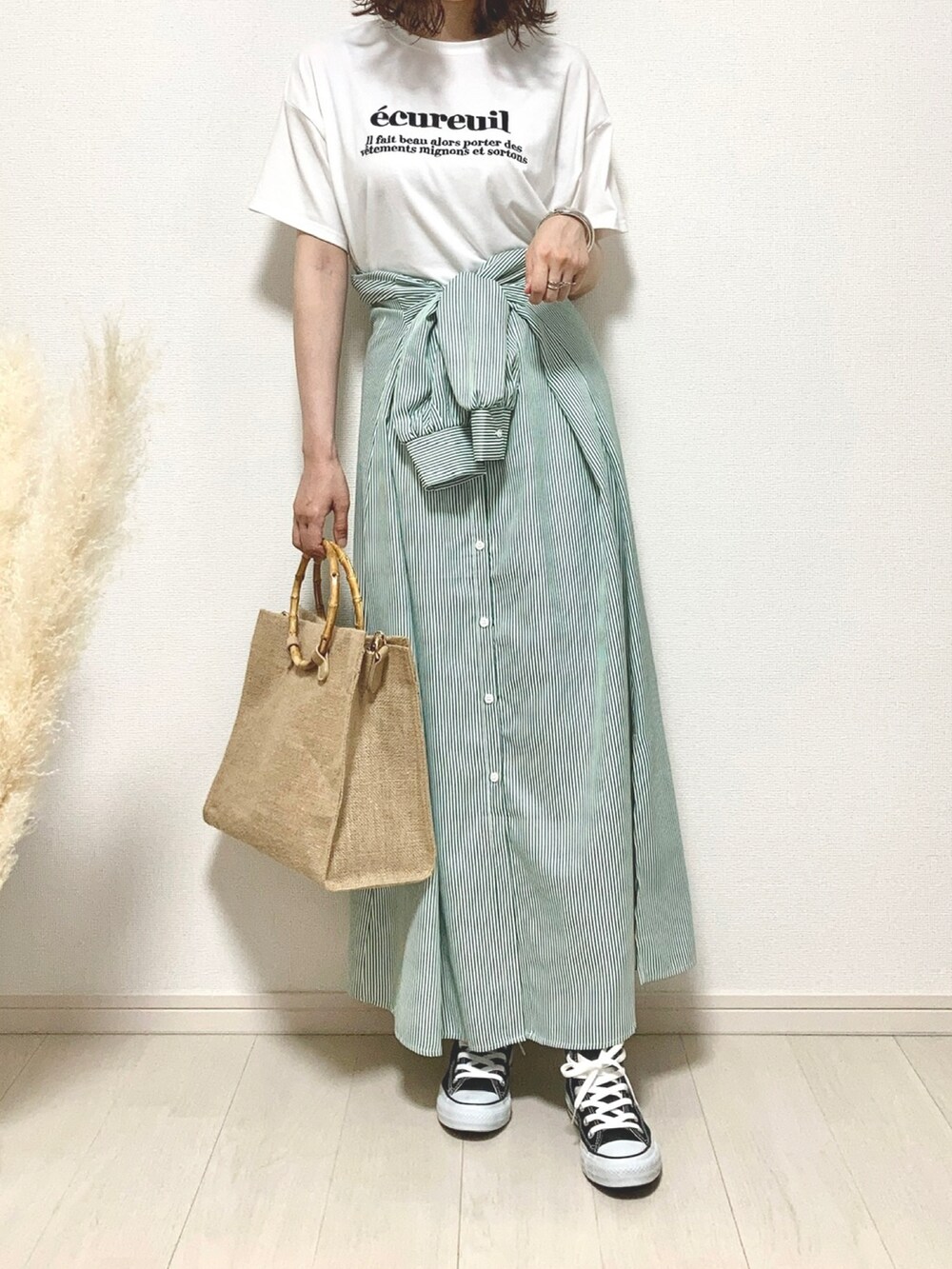 ホワイト系のTシャツ/カットソー、グリーン系のワンピース、ベージュ系のハンドバッグを着用したレディースの夏コーディネートの2枚目の写真