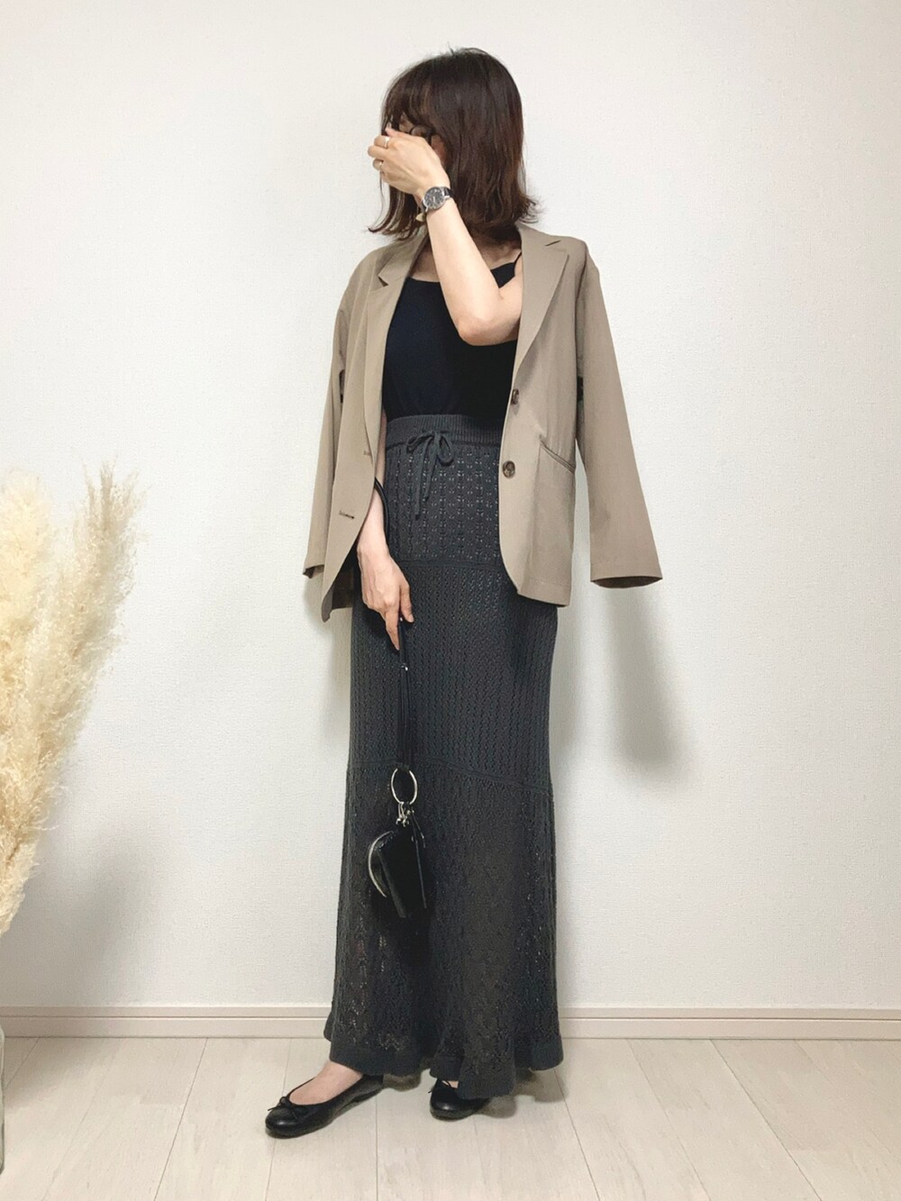 ブラウン系のテーラードジャケット、グレー系のスカート、ブラック系のバレエシューズを着用したレディースの夏コーディネートの4枚目の写真