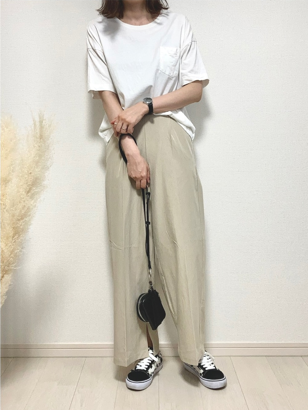 ホワイト系のTシャツ/カットソー、ベージュ系のその他パンツ、ブラック系のスニーカーを着用したレディースの夏コーディネートの2枚目の写真
