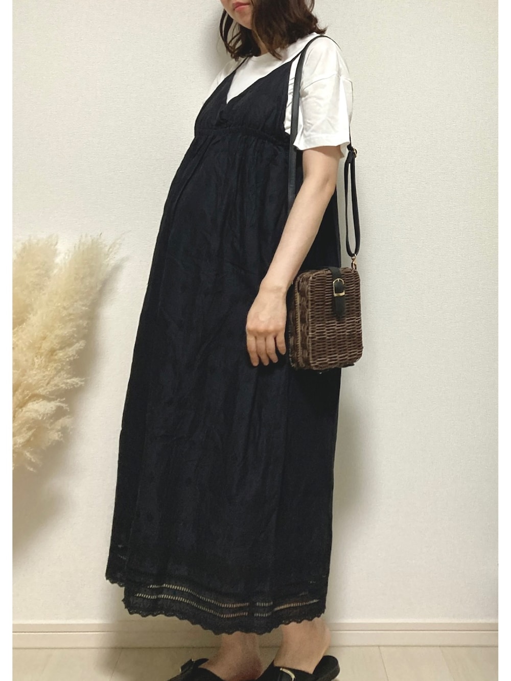 ベージュ系のベスト、ブラック系のワンピース、ブラウン系のかごバッグを着用したレディースの秋コーディネートの2枚目の写真