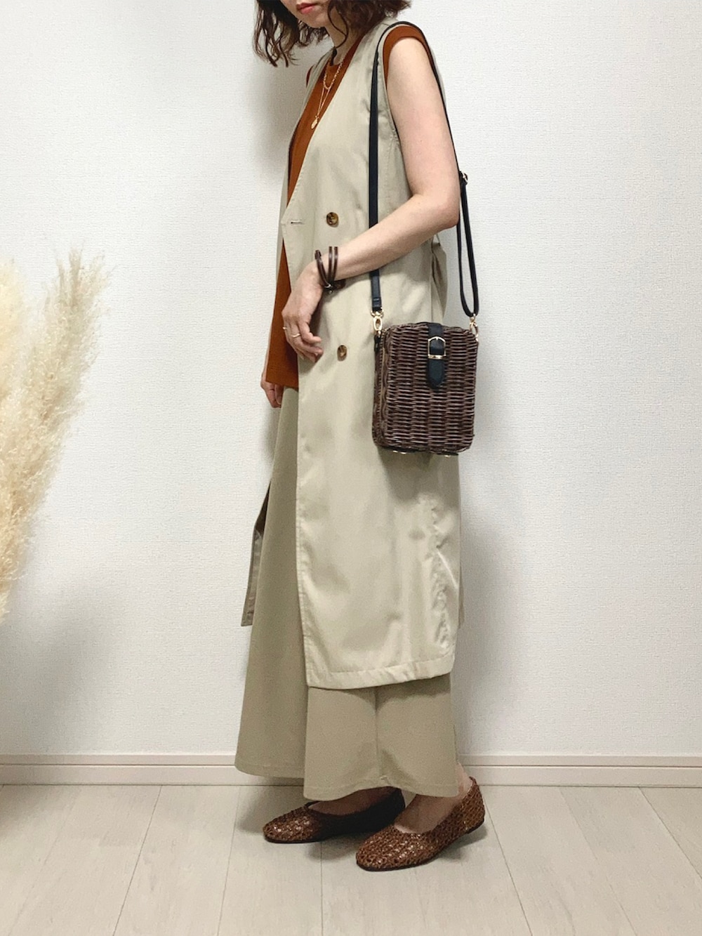 ブラウン系のTシャツ/カットソー、ベージュ系のベスト、ブラウン系のかごバッグを着用したレディースの夏コーディネートの2枚目の写真