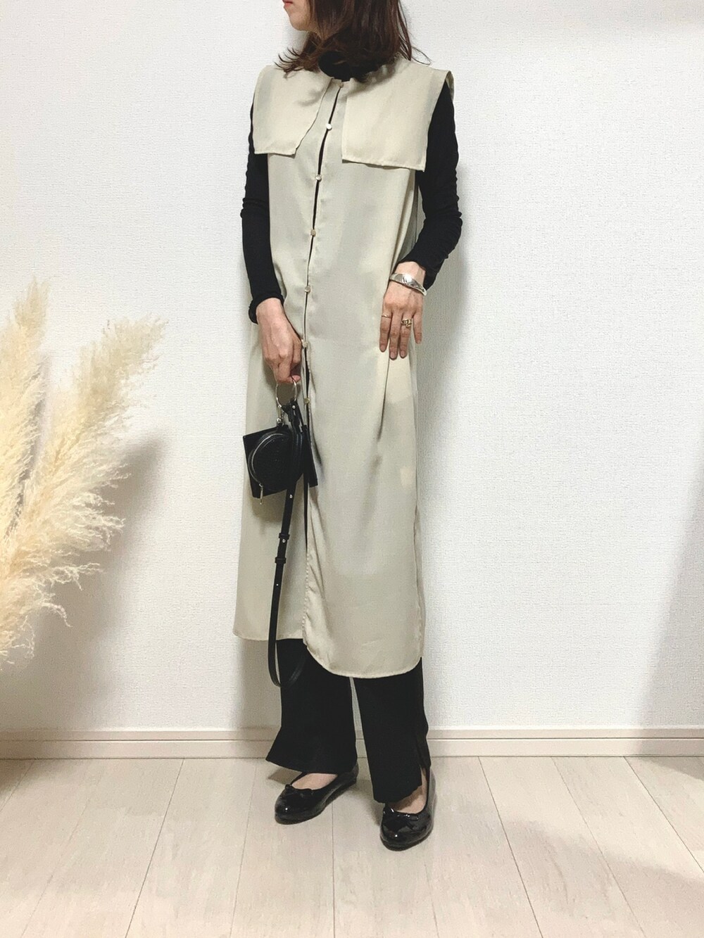 ブラック系のTシャツ/カットソー、ベージュ系のトップス、ブラック系のパンプスを着用したレディースの秋コーディネートの2枚目の写真