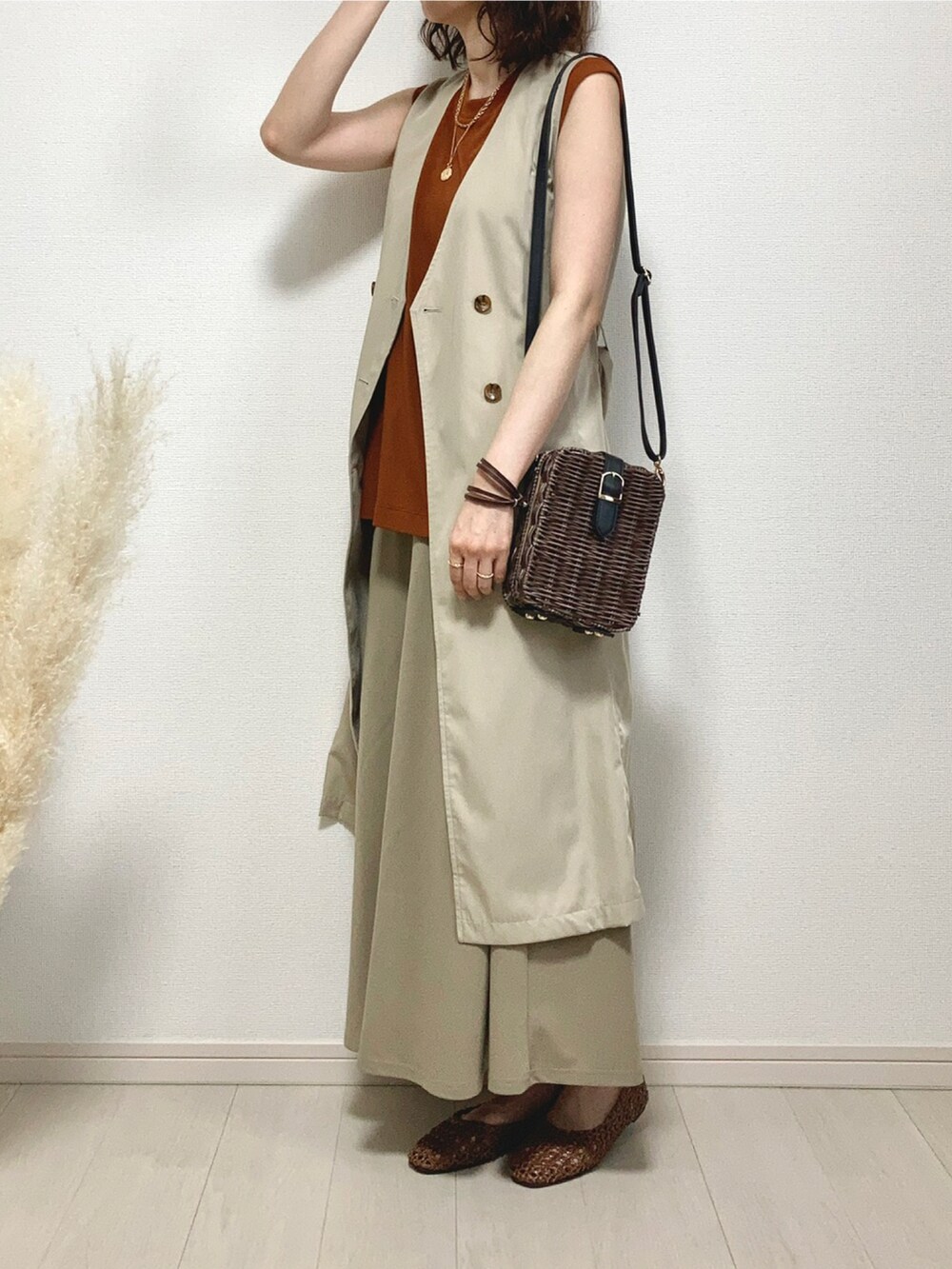 ブラウン系のTシャツ/カットソー、ベージュ系のベスト、ブラウン系のかごバッグを着用したレディースの夏コーディネートの4枚目の写真