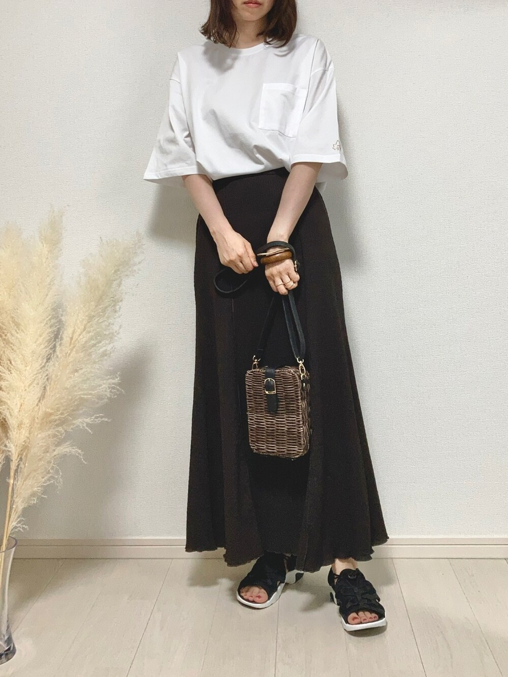 ホワイト系のTシャツ/カットソー、ブラウン系のスカート、ブラウン系のかごバッグを着用したレディースの夏コーディネートの3枚目の写真