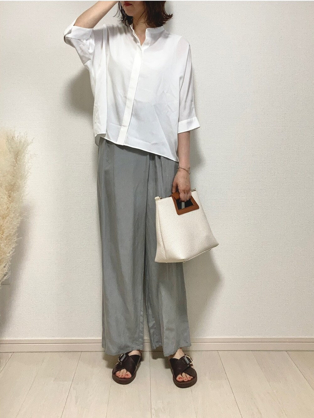 ホワイト系のシャツ/ブラウス、ブルー系のその他パンツ、ホワイト系のハンドバッグを着用したレディースの夏コーディネートの2枚目の写真