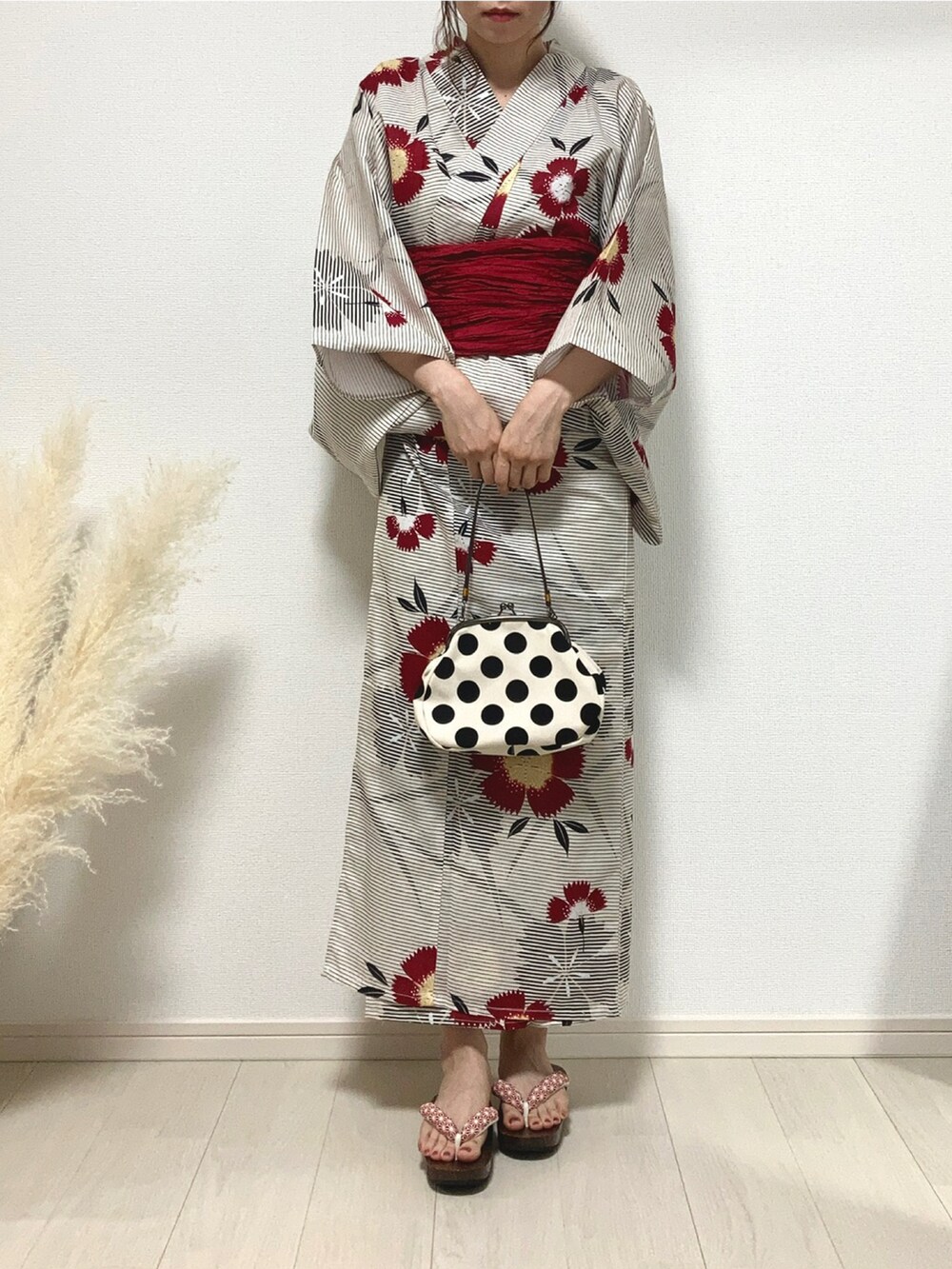 ピンク系のハンドバッグ、ブラック系の浴衣、レッド系の和装小物を着用したレディースの夏コーディネートの2枚目の写真