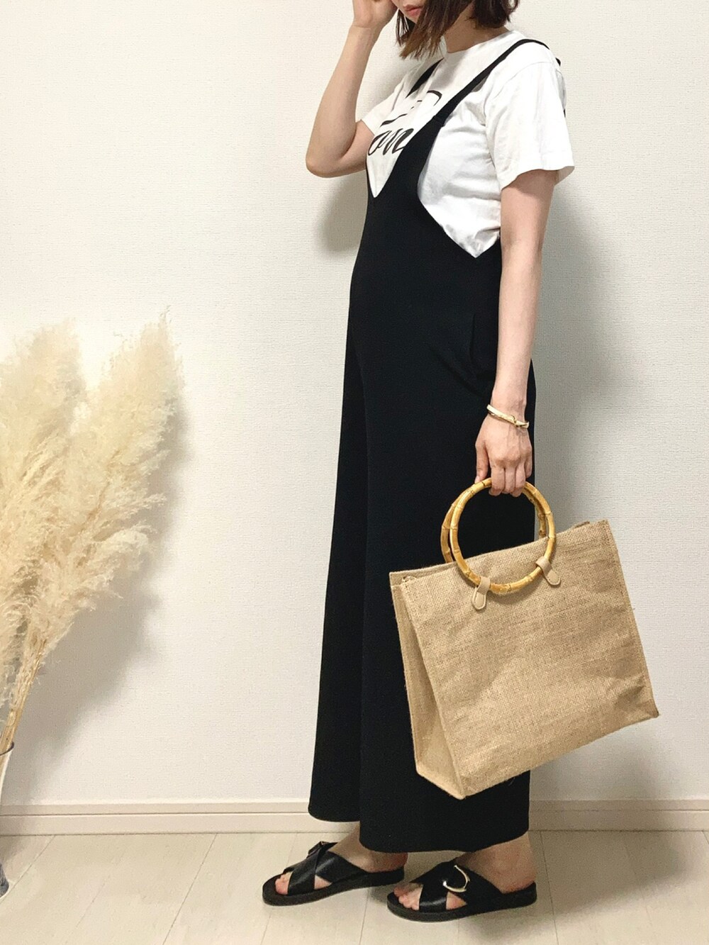 ホワイト系のTシャツ/カットソー、ブラック系のつなぎ/オールインワン、ベージュ系のハンドバッグを着用したレディースの夏コーディネートの2枚目の写真