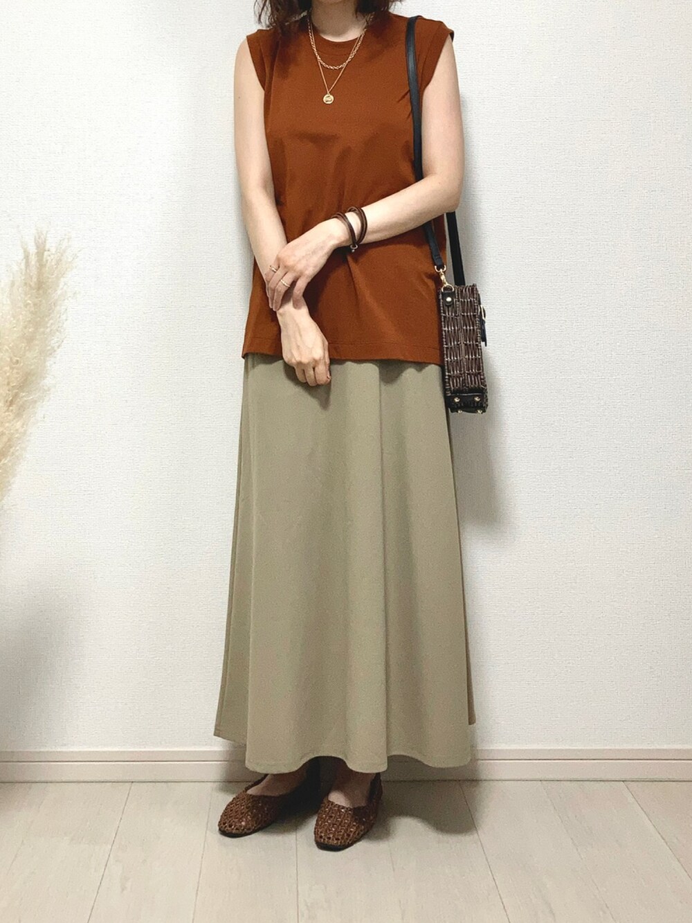ブラウン系のTシャツ/カットソー、ベージュ系のベスト、ブラウン系のかごバッグを着用したレディースの夏コーディネートの5枚目の写真