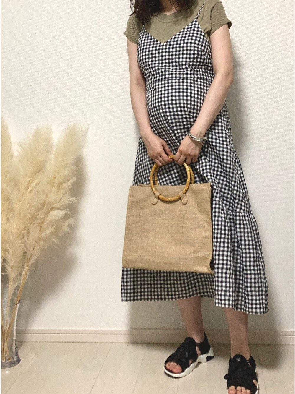 ブラック系のワンピース、ベージュ系のハンドバッグ、ブラック系のサンダルを着用したレディースの夏コーディネートの4枚目の写真