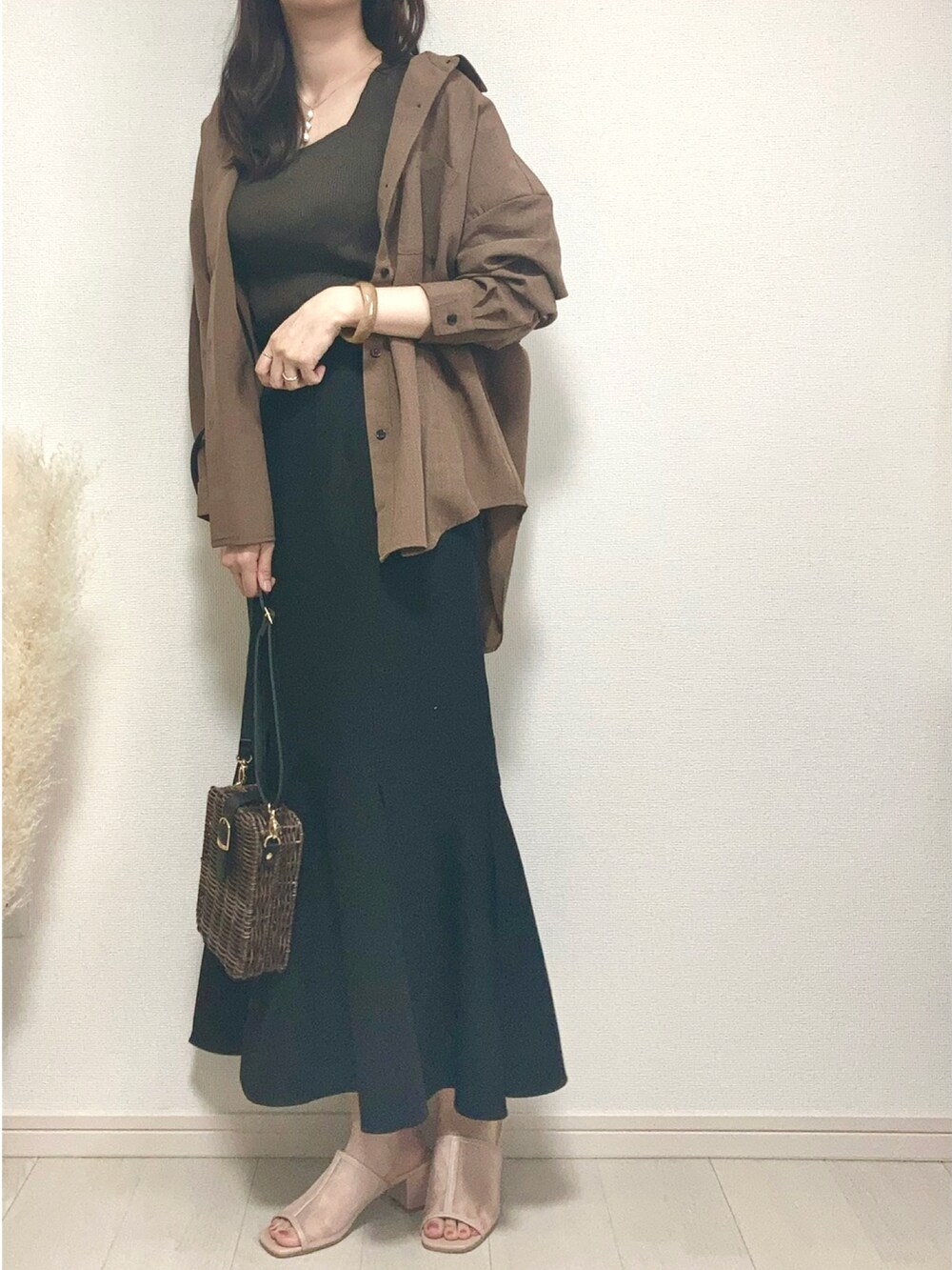 ブラウン系のシャツ/ブラウス、ブラウン系のタンクトップ、ブラック系のスカートを着用したレディースの春コーディネートの2枚目の写真