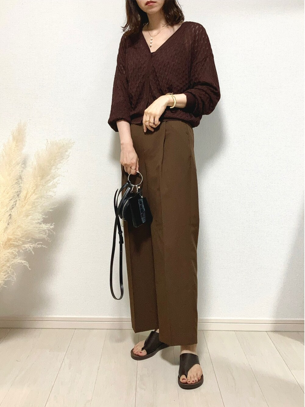 ブラウン系のニット/セーター、ブラウン系のスラックス、ブラウン系のサンダルを着用したレディースの夏コーディネートの2枚目の写真