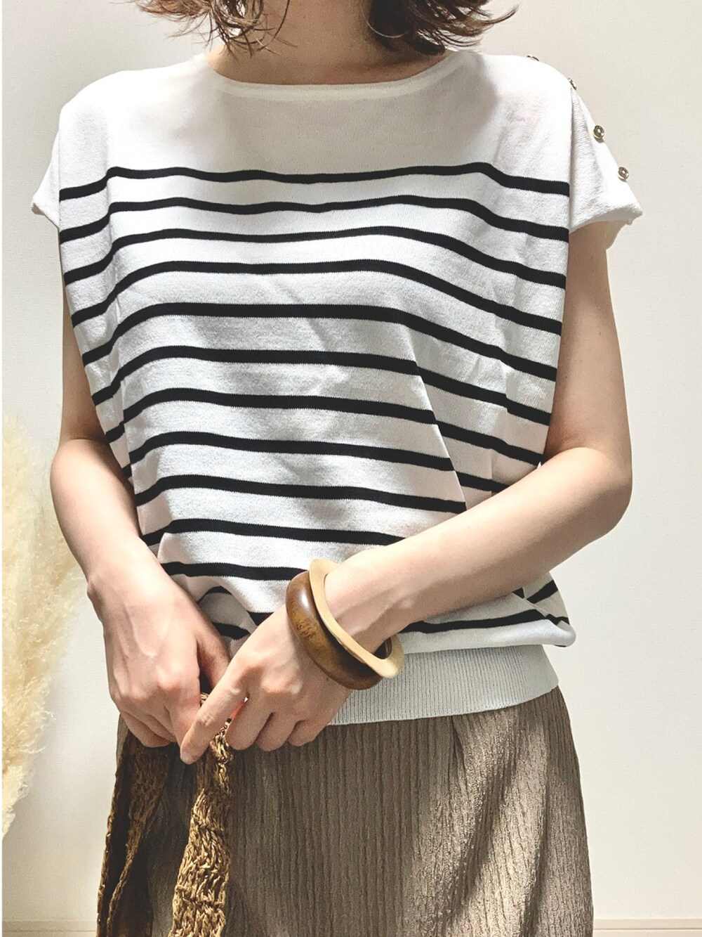 ホワイト系のトップス、ブラウン系のスカート、ブラウン系のショルダーバッグを着用したレディースの夏コーディネートの4枚目の写真