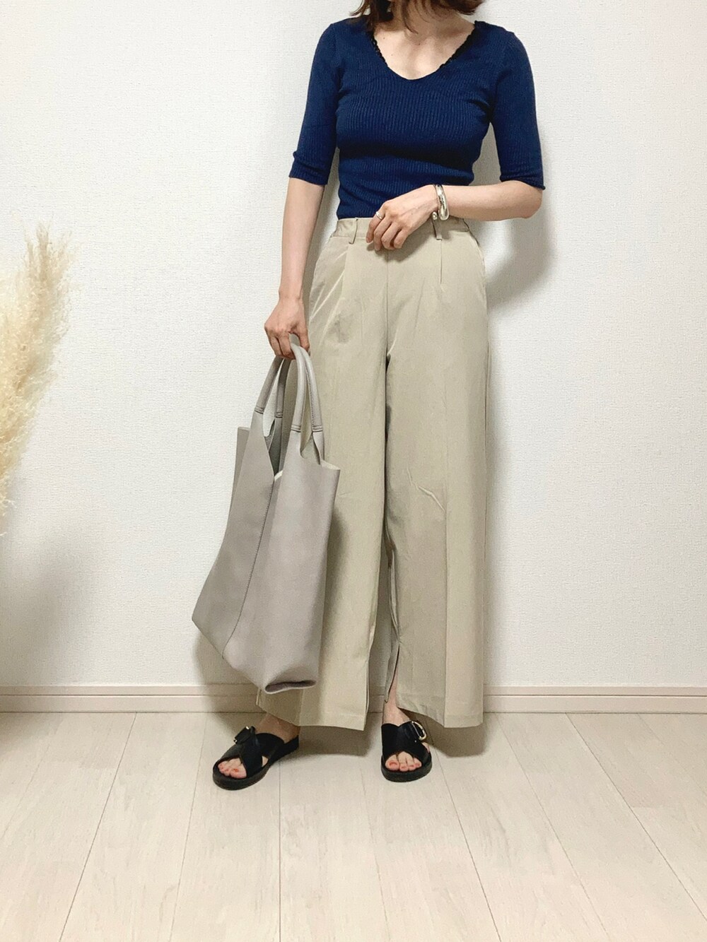 ブルー系のニット/セーター、ベージュ系のその他パンツ、ホワイト系のトートバッグを着用したレディースの夏コーディネートの2枚目の写真