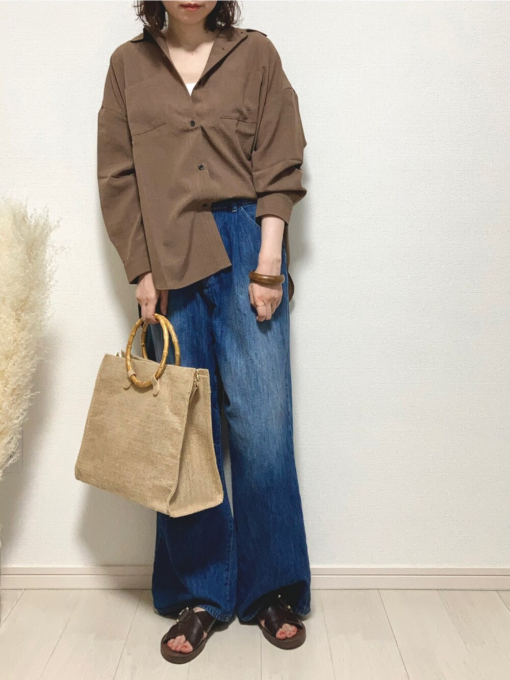 ブラウン系のシャツ/ブラウス、ブルー系のデニムパンツ、ブラウン系のサンダルを着用したレディースの夏コーディネートの3枚目の写真