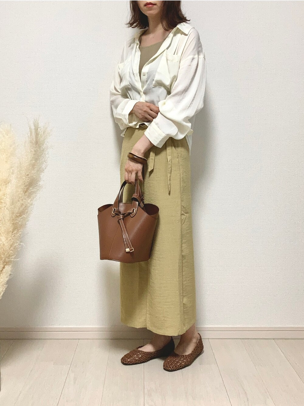 ベージュ系のタンクトップ、ホワイト系のシャツ/ブラウス、イエロー系のスカートを着用したレディースの夏コーディネートの3枚目の写真