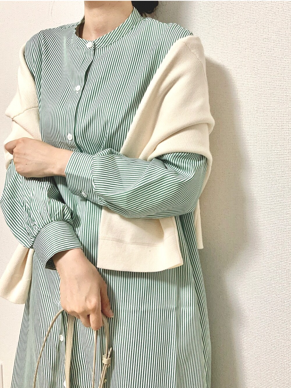 グリーン系のワンピース、ベージュ系のショルダーバッグ、ホワイト系のデニムパンツを着用したレディースの春コーディネートの3枚目の写真